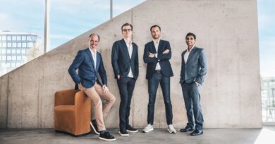 Four men standing in front of a concrete wall.