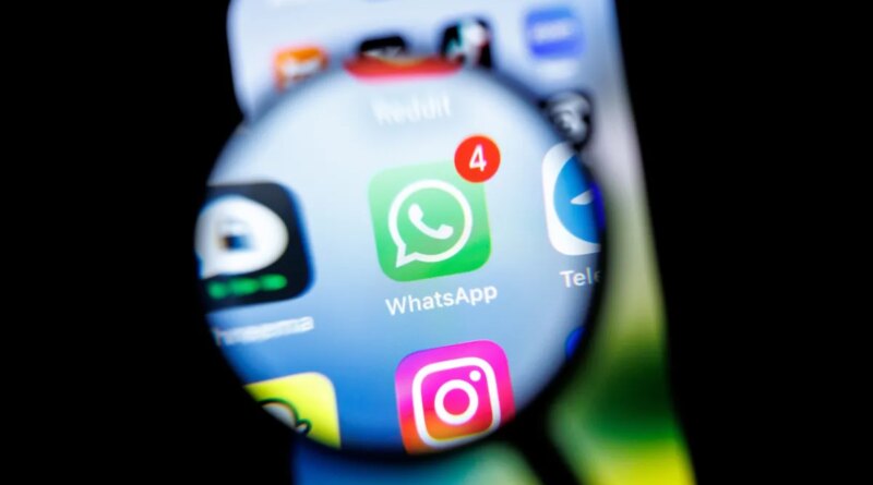 in this photo illustration, the Whatsapp app logo can be seen through a magnifying glass on the display of a smartphone.