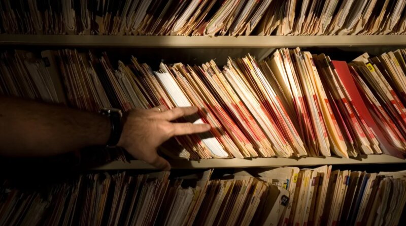 tons of medical records on a shelf in a darkened room