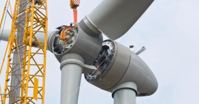 A crane positions the rotor of a wind turbine during construction.