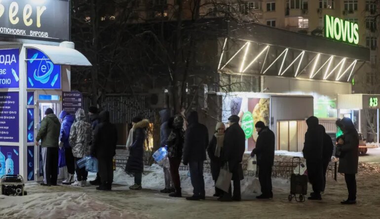 Residents stand in line to fill up bottles with fresh drinking water during a power blackout after critical civil infrastructure was hit by recent Russian missile and drone attacks, amid Russia's attack on Ukraine, in Kyiv, Ukraine January 24, 2026. REUTERS/Gleb Garanich