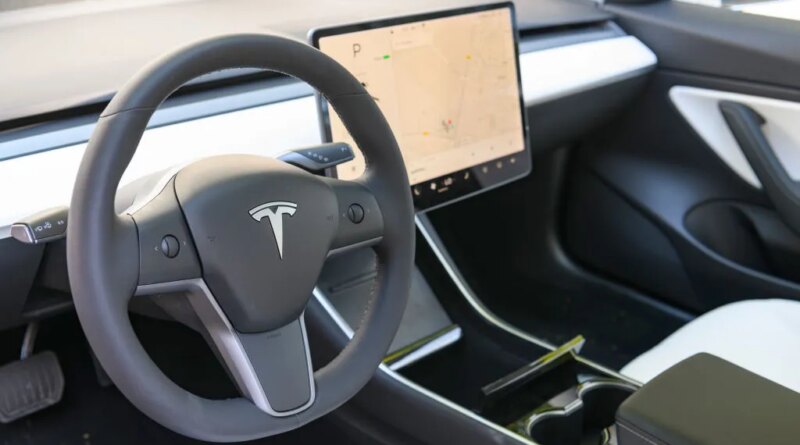 interior of Tesla EV showing steering wheel and center console