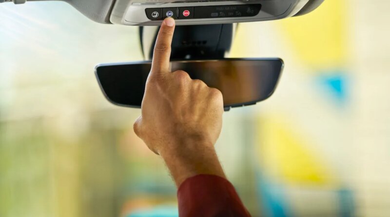 Person pushes the blue OnStar button in a GM vehicle.