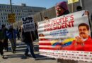 Demonstrators hold signs opposing US intervention in Venezuela, including a large banner with Nicolas Maduro’s image and the text ‘The People’s President’.