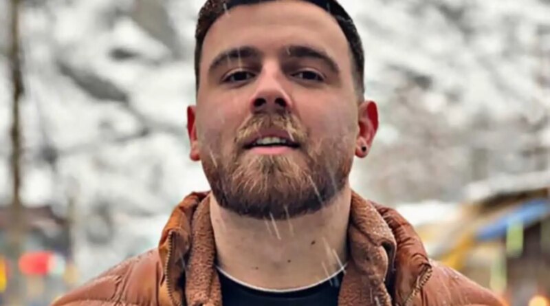 Erfan Soltani in an orange puffer jacket and woolen shirt.