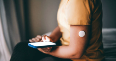 person sitting, with glucose monitor on their arm