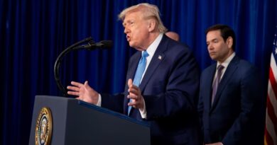 Donald Trump speaks at a podium with the presidential seal, gesturing with both hands, as another man stands behind him.