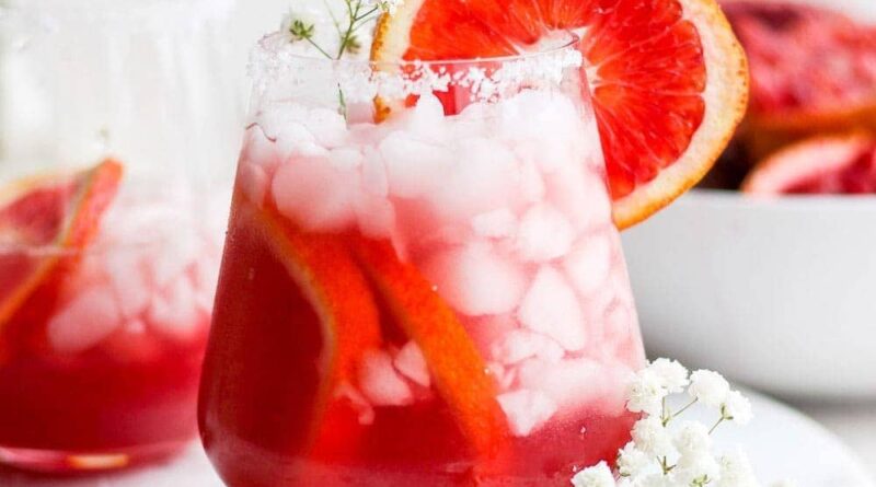 Two glasses of Blood Orange Margarita on a white plate.