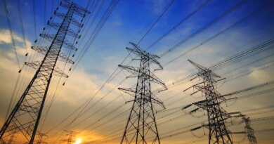 High tension power lines against a sunset