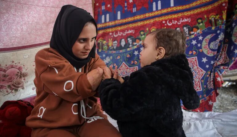 Nebal with her two-year-old daughter, Rita [Abdelhakim Abu Riash/ Al Jazeera]
