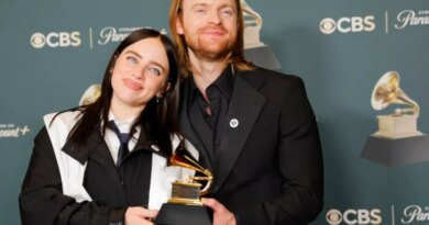 Billie Eilish and Finneas wearing ICE Out pins pose with the award for Song of the Year for "WILDFLOWER"