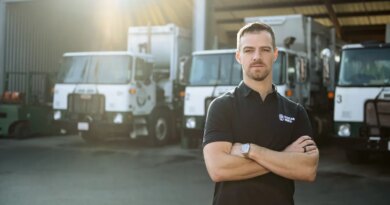 Image of Mark Hoadley, Hauler Hero co-founder and CEO, in front of garbage trucks.