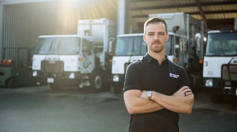 Image of Mark Hoadley, Hauler Hero co-founder and CEO, in front of garbage trucks.