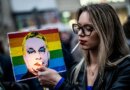 FILE PHOTO: A woman lights a cigarette placed in a placard depicting Hungary's Prime Minister Viktor Orban, during a demonstration, after the Hungarian parliament passed a law that bans LGBTQ+ communities from holding the annual Pride march and allows a broader constraint on freedom of assembly, in Budapest, Hungary, March 25, 2025. REUTERS/Marton Monus/File Photo