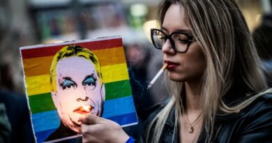 FILE PHOTO: A woman lights a cigarette placed in a placard depicting Hungary's Prime Minister Viktor Orban, during a demonstration, after the Hungarian parliament passed a law that bans LGBTQ+ communities from holding the annual Pride march and allows a broader constraint on freedom of assembly, in Budapest, Hungary, March 25, 2025. REUTERS/Marton Monus/File Photo