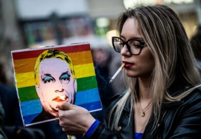 FILE PHOTO: A woman lights a cigarette placed in a placard depicting Hungary's Prime Minister Viktor Orban, during a demonstration, after the Hungarian parliament passed a law that bans LGBTQ+ communities from holding the annual Pride march and allows a broader constraint on freedom of assembly, in Budapest, Hungary, March 25, 2025. REUTERS/Marton Monus/File Photo
