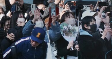 Panda lovers wave goodbye to a truck believed to be carrying the twin pandas upon a departure from Ueno Zoo in Tokyo on January 27, 2026, heading towards their return to China. (Photo by Kazuhiro NOGI / AFP)