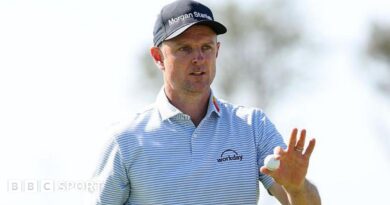 Justin Rose holds a golf ball up