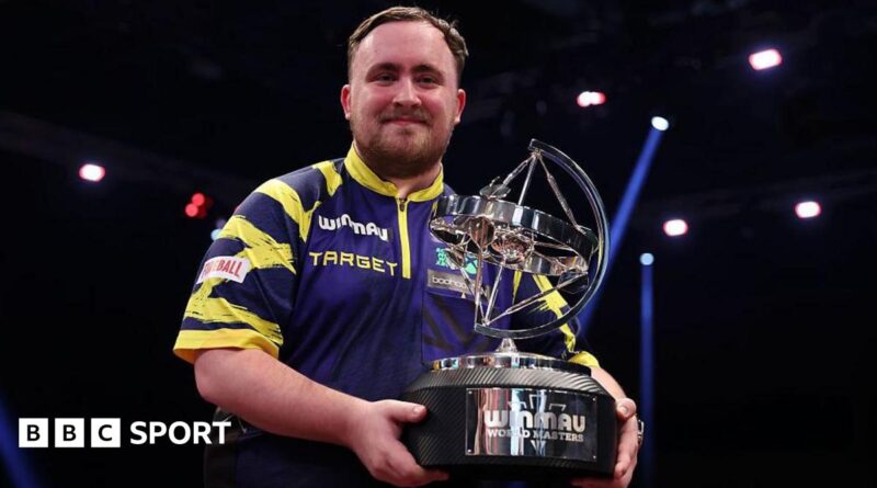 Luke Littler holding the World Masters trophy