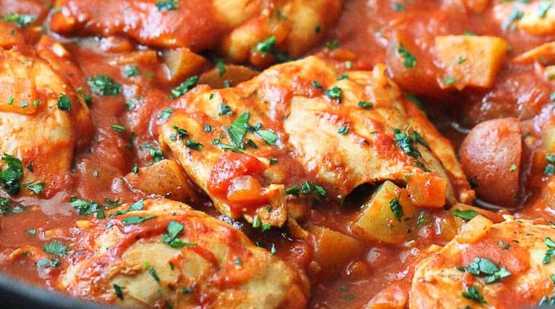 One-pot curry and tomato chicken in a skillet.