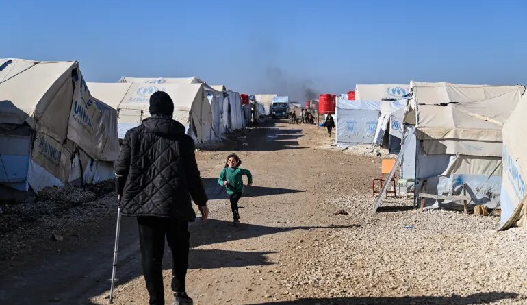 AL HASAKAH, SYRIA - JANUARY 26: Detainees are seen between tents at the al-Hol camp on January 26, 2026 in Al Hasakah, Syria. The al-Hol camp (also spelled Al-Hawl) in Syria's northeastern Hasakah province has come under control by Syrian government forces, following the withdrawal of the Kurdish-led Syrian Democratic Forces (SDF) in recent days. The camp houses around 24,000 people, many of whom are women and children, with alleged links to the jihadist group Islamic State (IS), also referred to as ISIS in the region. Clashes between the SDF and government forces this month over the former's integration with state institutions has seen large swaths of Kurdish-controlled territory ceded. Under a ceasefire agreement, camps and prisons housing ISIS detainees previously held by the US-backed Kurdish forces are to be transferred to the government. The United Nations (UN) has said it will take over management of al-Hol, resuming the delivery of humanitarian supplies to the camp, amid dire conditions. (Photo by Abdulmonam Eassa/Getty Images)