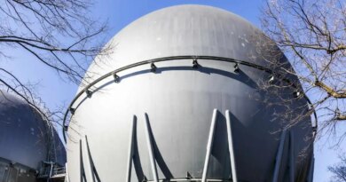 Industrial hydrogen storage tank stands against a blue sky.