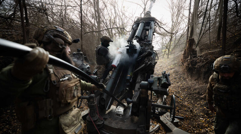 Soldiers firing a howitzer.