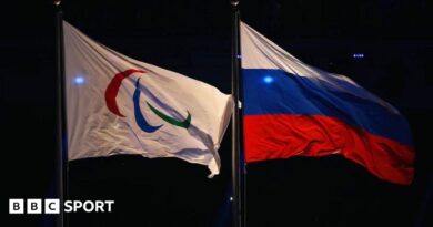 Paralympic flag and Russia flag flying side-by-side