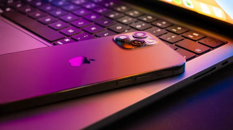 MacBook pro 2021 half open with Iphone 13 lit by retina display