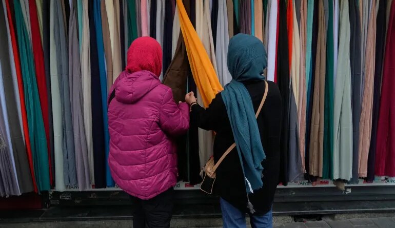 Women examine headscarves for sale in northern Tehran, Iran, Tuesday, March 24, 2026. (AP Photo/Vahid Salemi)