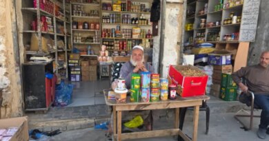 Nahed Barbakh, 60, shop owner and trader, sits at a table in front of his store