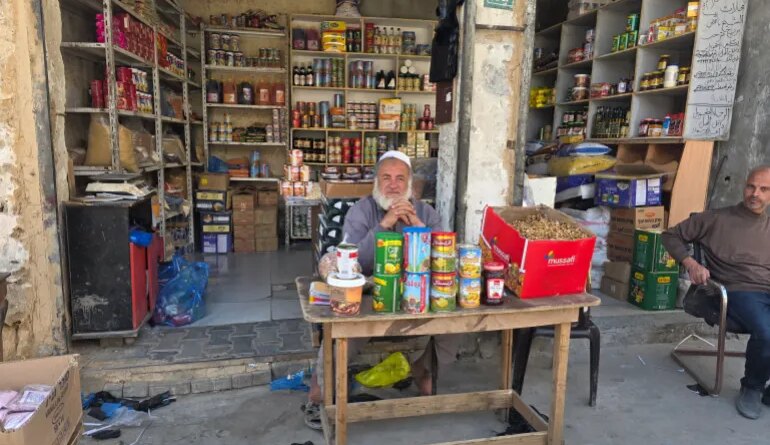Nahed Barbakh, 60, shop owner and trader, sits at a table in front of his store