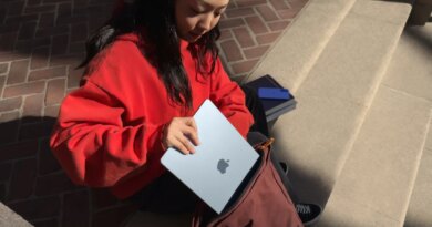 young woman putting Apple MacBook Air into a satchel