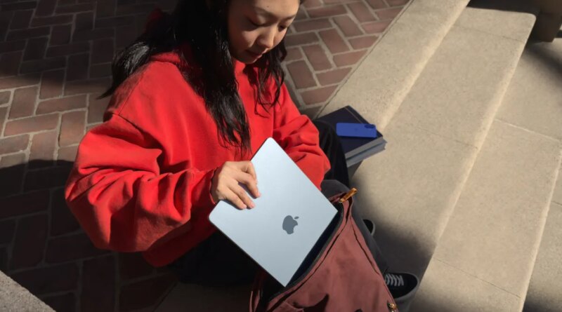 young woman putting Apple MacBook Air into a satchel