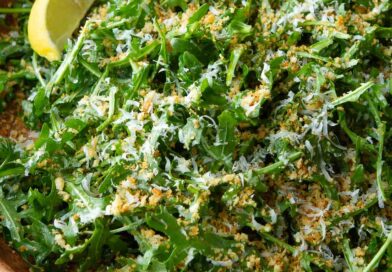 Arugula salad with Parmesan and panko in a wooden bowl.