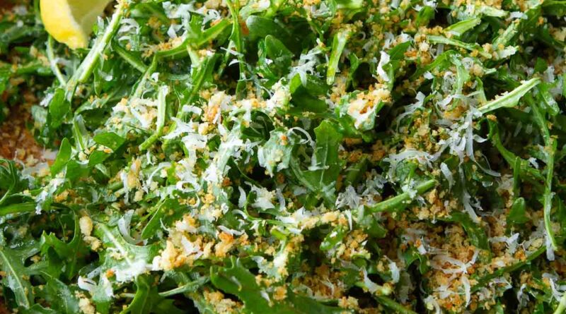 Arugula salad with Parmesan and panko in a wooden bowl.