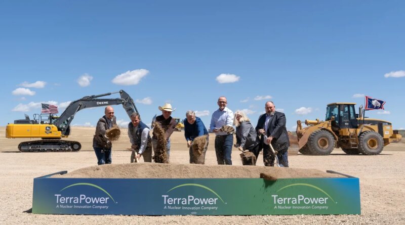 Seven people shovel dirt at a ceremonial groundbreaking.