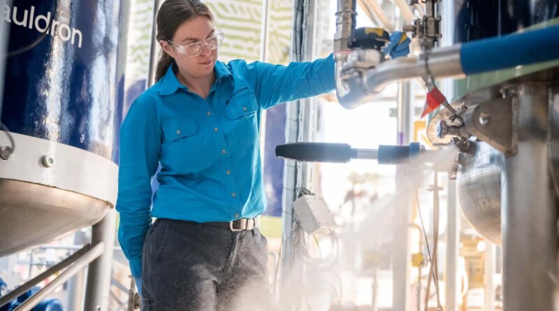 A woman operates a fermenter.