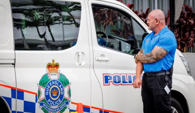 A hotel security member stands beside a police van at the entrance to the Royal Pines Resort, where members of the Iranian womens football team are staying, on the Gold Coast on March 9, 2026. Australia must protect the visiting Iranian women's football team, the son of the nation's late shah urged March 9, warning their refusal to sing the national anthem before a match could have "dire consequences". (Photo by Patrick HAMILTON / AFP)