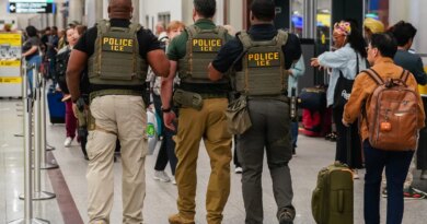 Immigration and Customs Enforcement (ICE) agents as travelers wait in line to be screened at a Transportation Security Administration (TSA) checkpoint at Hartsfield-Jackson Atlanta International Airport (ATL) in Atlanta, Georgia, US, on Monday, March 23, 2026.