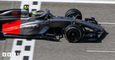 Lewis Hamilton drives the new Ferrari on track in Bahrain, with a McLaren in the background