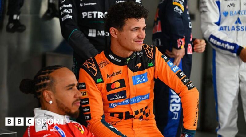 Lewis Hamilton, wearing his red Ferrari suit and Lando Norris, wearing his papaya Mclaren suit, pose during the F1 2026 photocall in Bahrain