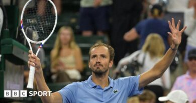 Daniil Medvedev holds up a tennis racquet