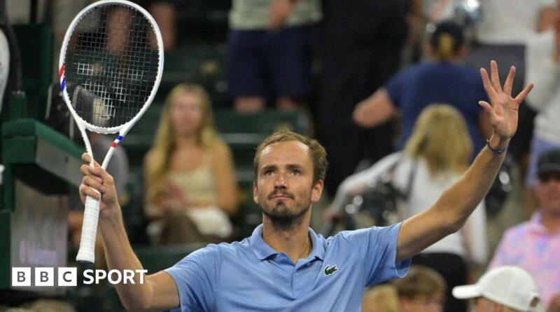 Daniil Medvedev holds up a tennis racquet