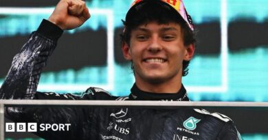 Kimi Antonelli smiles and clenches his fist in celebration on the podium after winning the Japanese Grand Prix