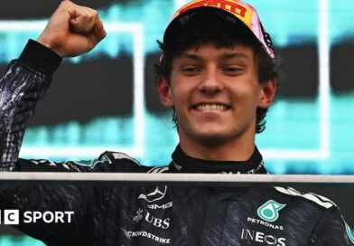 Kimi Antonelli smiles and clenches his fist in celebration on the podium after winning the Japanese Grand Prix