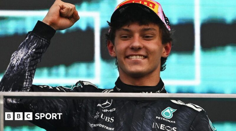 Kimi Antonelli smiles and clenches his fist in celebration on the podium after winning the Japanese Grand Prix