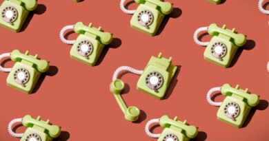 High angle view of some vintage green rotary telephones arranged on a brown background, showcasing retro communication technology with a nostalgic and artistic flair