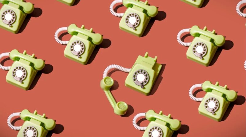 High angle view of some vintage green rotary telephones arranged on a brown background, showcasing retro communication technology with a nostalgic and artistic flair