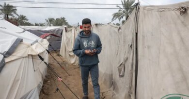 Abdel Karim Salman heads daily to the charging station to charge his phone and his wife’s phone, which they use as a source of light in their tent throughout the night [Abdelhakim Abu Riash/ Al Jazeera]